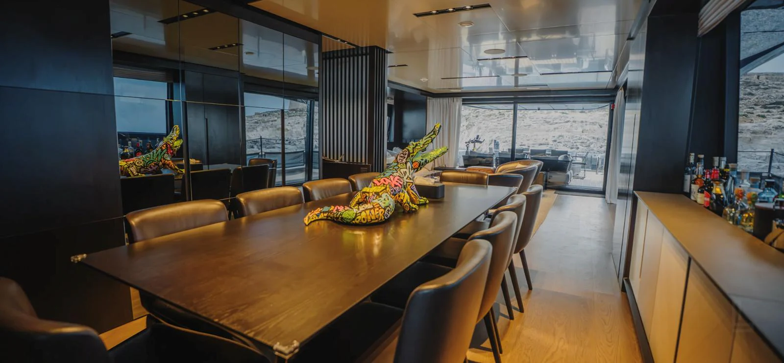 The yacht's dining area features a sleek, modern design with a large table and comfortable seating, complemented by stylish decor and ample natural light. aboard BYEEE... Yacht for Sale
