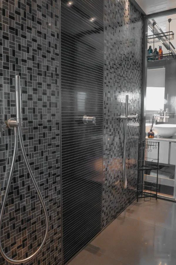 The yacht's bathroom features modern fixtures and a stylish mosaic tile design. aboard BYEEE... Yacht for Sale