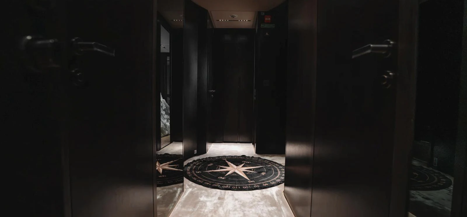 The yacht's interior features a luxurious hallway with a striking compass rose rug. aboard BYEEE... Yacht for Sale