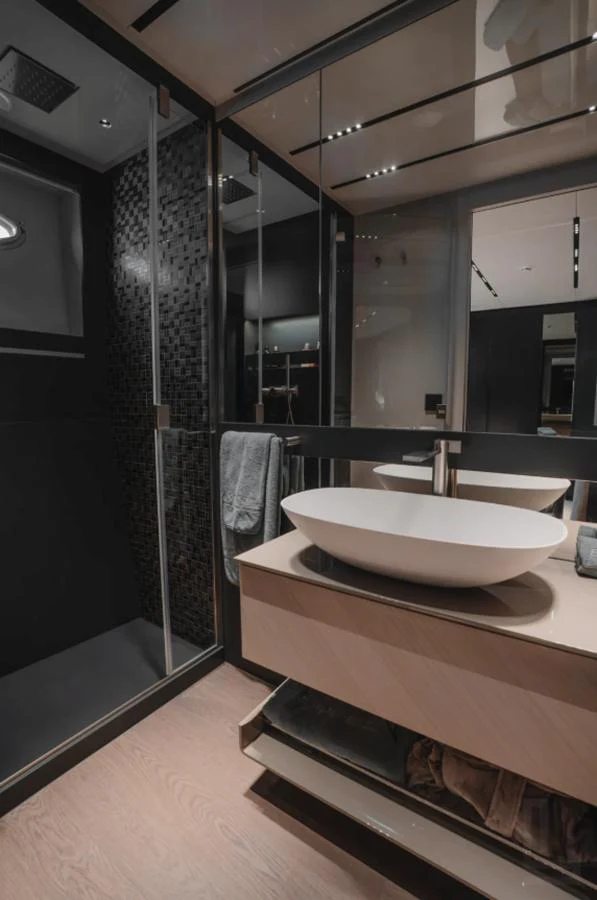 A sleek and modern yacht bathroom with a vessel sink and glass-enclosed shower. aboard BYEEE... Yacht for Sale