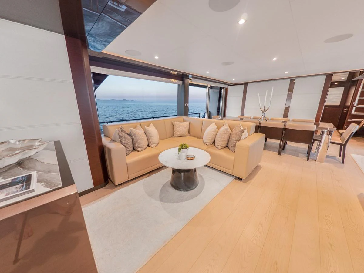 The salon features a spacious seating area with a large beige sofa and a stylish coffee table, offering a comfortable and elegant space to relax. aboard LONE STAR Yacht for Sale