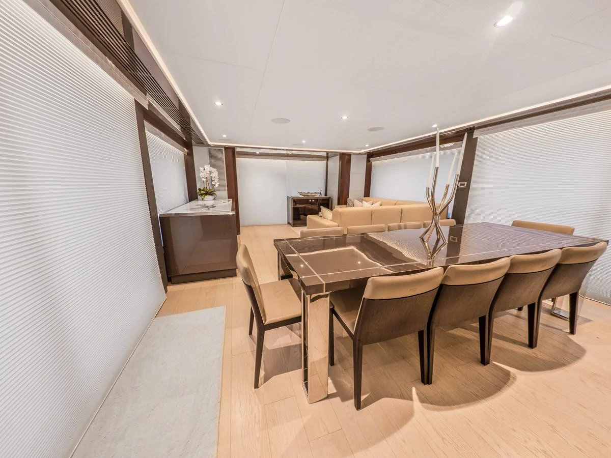 The yacht's dining area features a sleek table with comfortable seating, complemented by modern decor and ample natural light. aboard LONE STAR Yacht for Sale