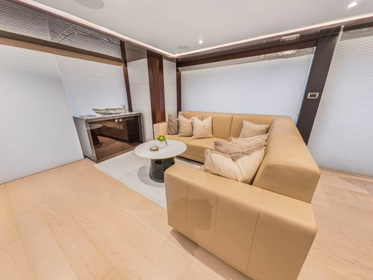 The yacht's interior features a cozy seating area with a plush L-shaped sofa and a modern coffee table. aboard LONE STAR Yacht for Sale