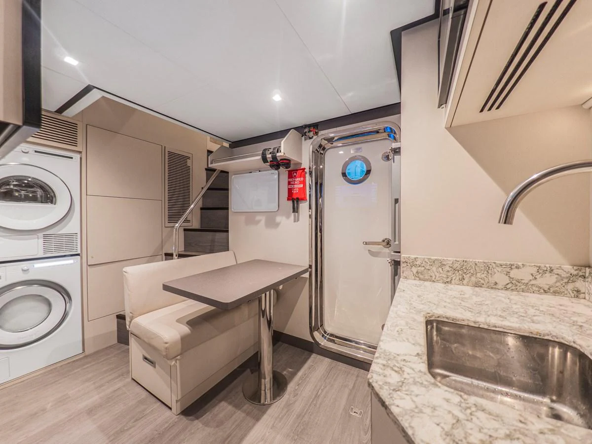 The yacht's interior features a compact and functional galley area with a dining nook and laundry facilities. aboard LONE STAR Yacht for Sale