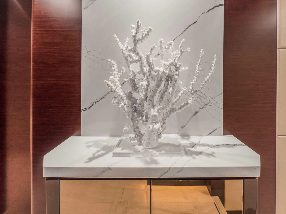 A sophisticated decorative coral piece is displayed on a marble surface, framed by rich wooden panels. aboard LONE STAR Yacht for Sale