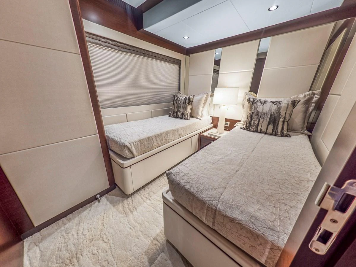 The guest stateroom features twin beds with elegant bedding and a cozy ambiance. aboard LONE STAR Yacht for Sale