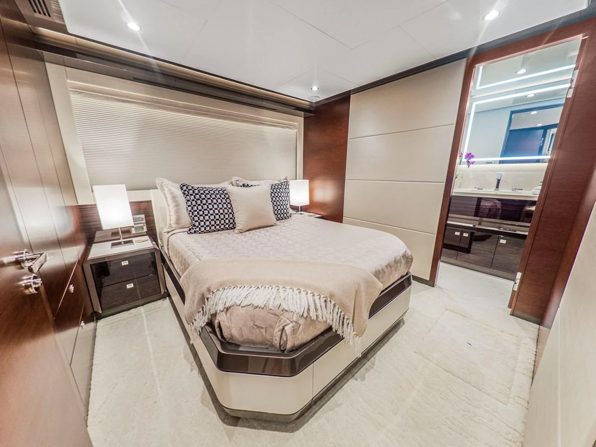A luxurious stateroom featuring a comfortable bed with elegant bedding and modern lighting. aboard LONE STAR Yacht for Sale