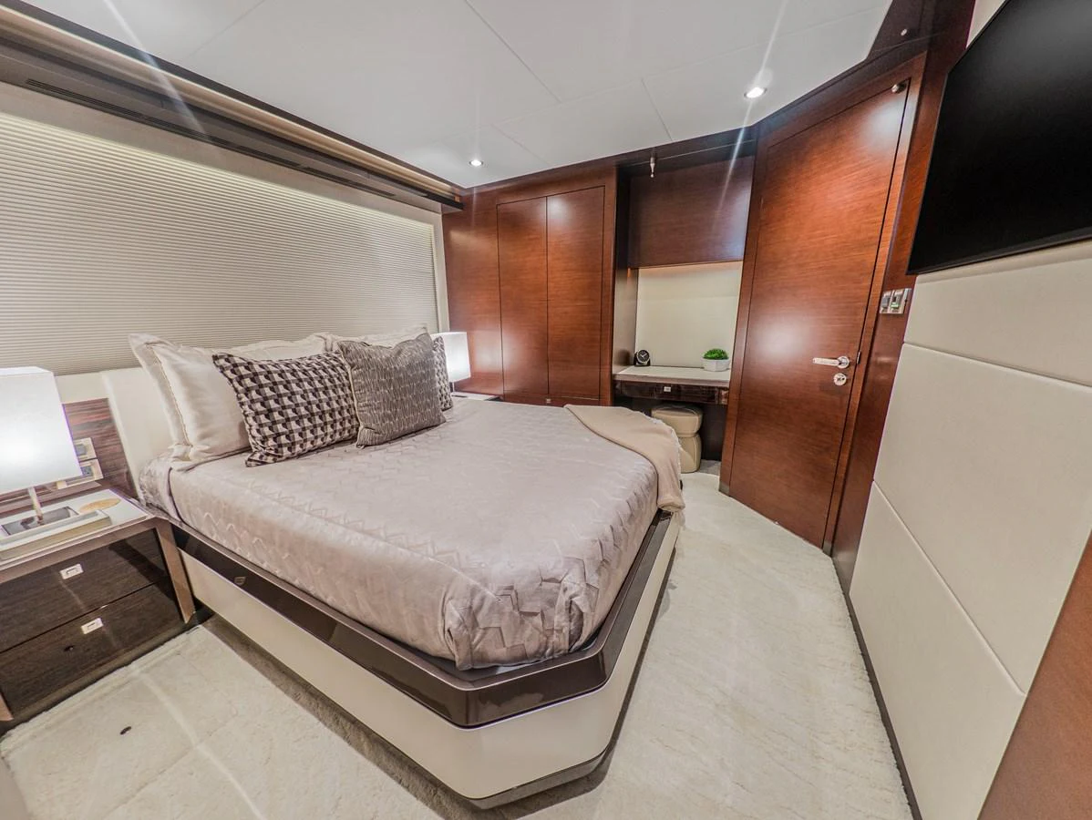 The stateroom features a luxurious bed with elegant bedding and modern wooden accents. aboard LONE STAR Yacht for Sale