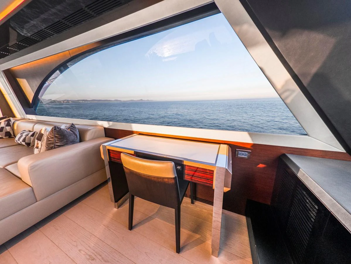 The salon features a stylish seating area with a large window offering stunning ocean views. aboard LONE STAR Yacht for Sale