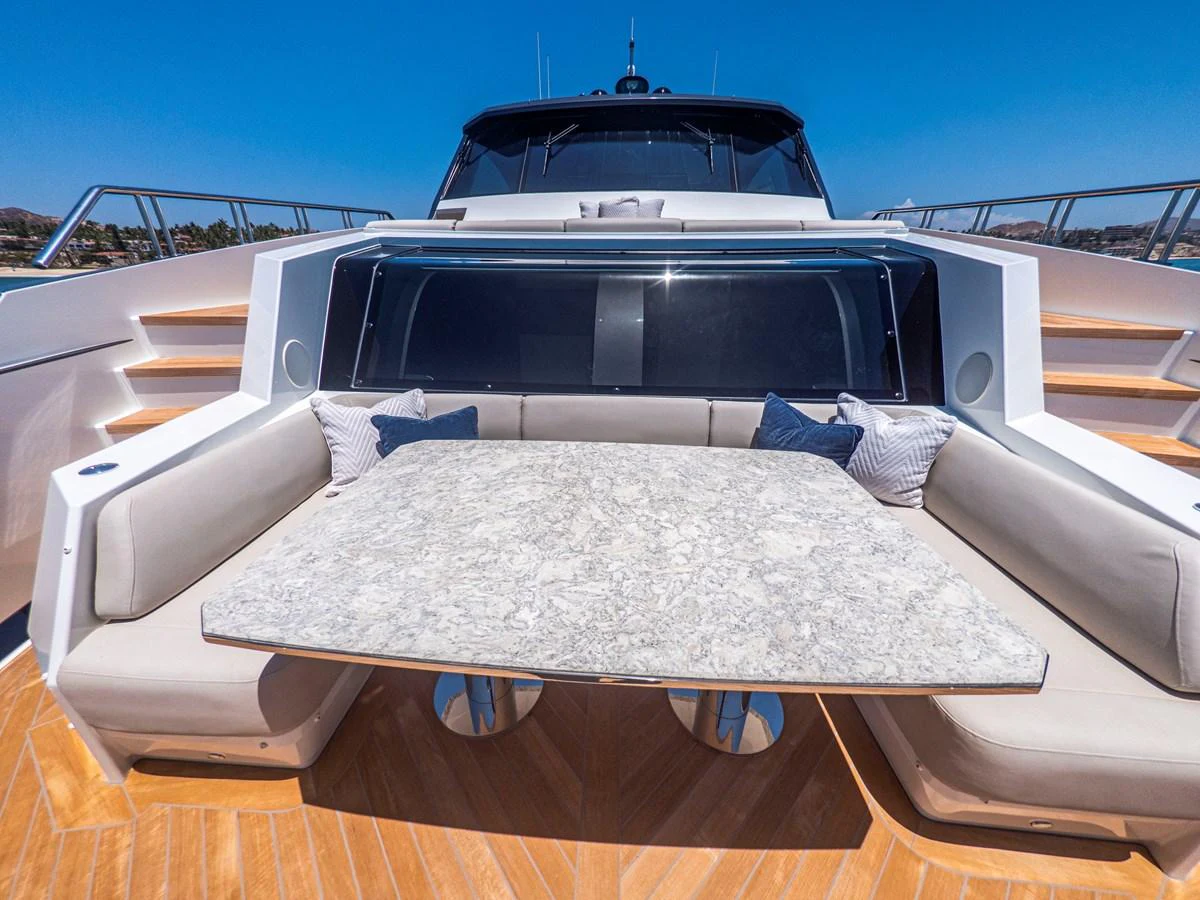 The aft deck features a luxurious seating area with a marble table, perfect for alfresco dining. aboard LONE STAR Yacht for Sale