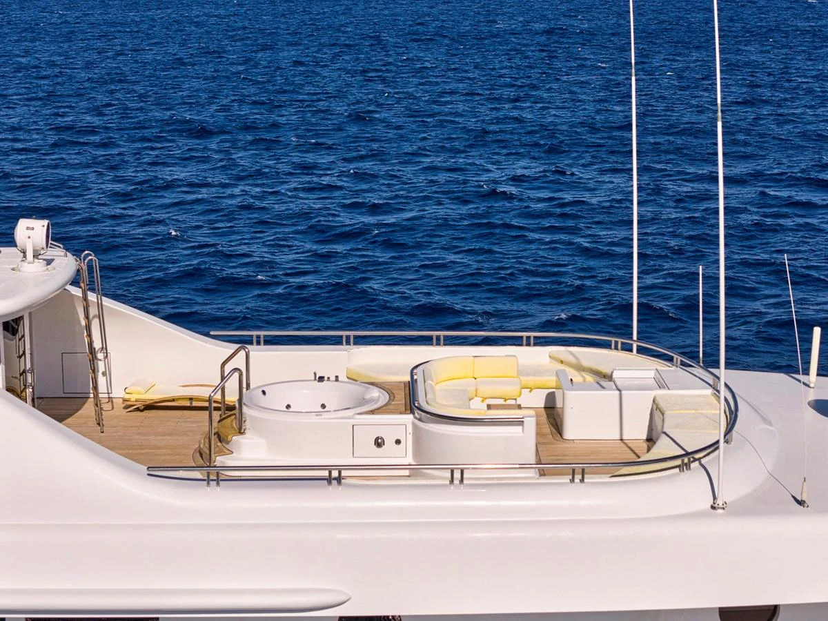 The sundeck features a luxurious hot tub and ample seating with a stunning ocean backdrop. aboard SAHAB IV Yacht for Sale