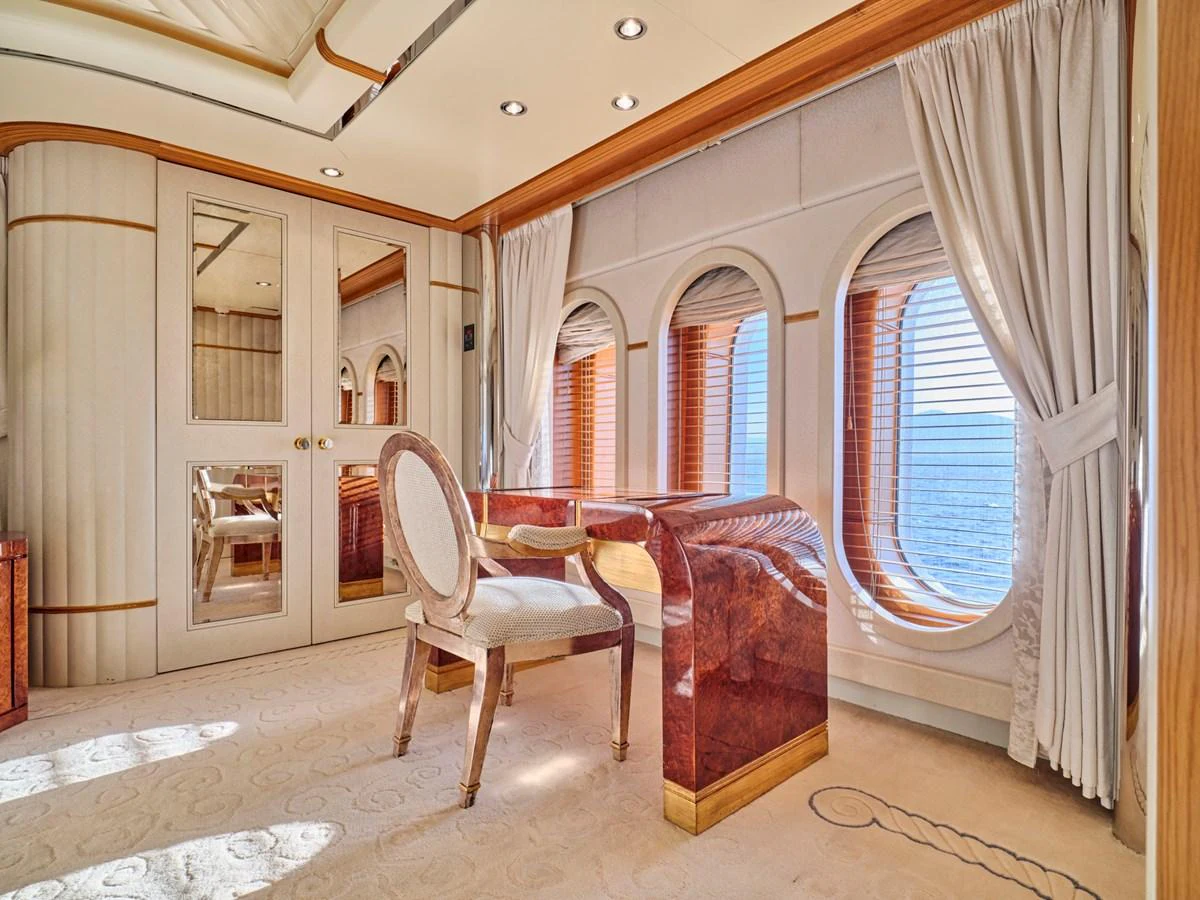 The yacht's interior features a luxurious study area with elegant wood finishes and large windows offering stunning ocean views. aboard SAHAB IV Yacht for Sale