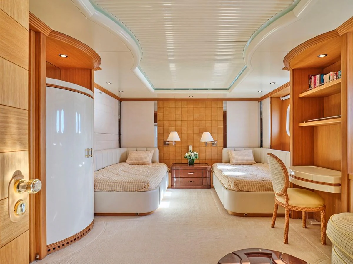 The guest stateroom features two twin beds, a writing desk, and elegant wood paneling. aboard SAHAB IV Yacht for Sale