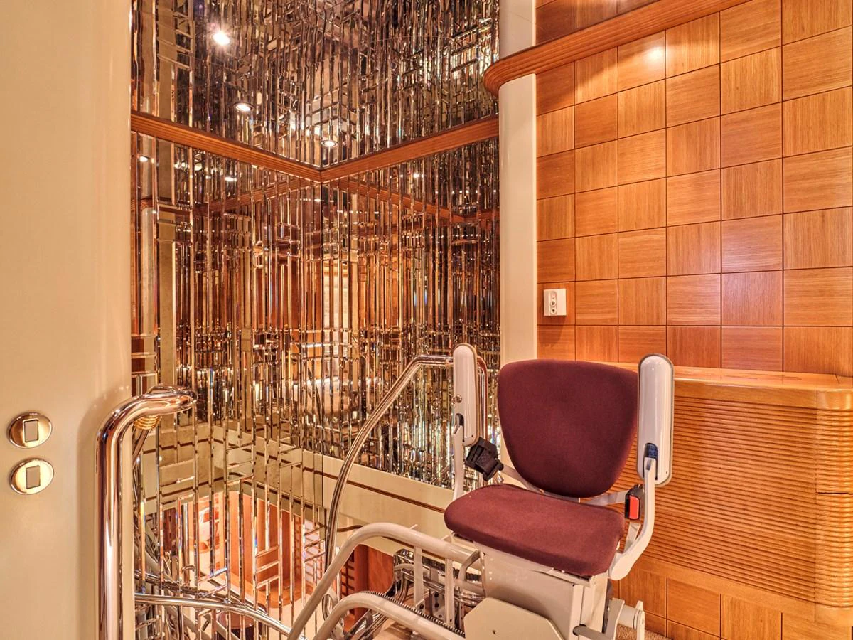 The yacht features a luxurious elevator with elegant wood paneling and mirrored walls. aboard SAHAB IV Yacht for Sale