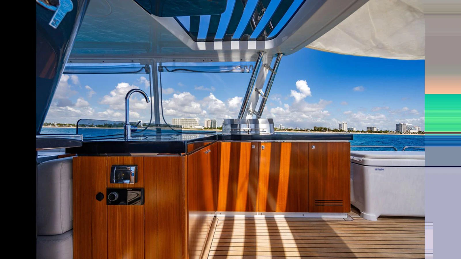 The yacht's galley features sleek wooden cabinetry and modern appliances with a stunning ocean view. aboard NIVASA Yacht for Sale