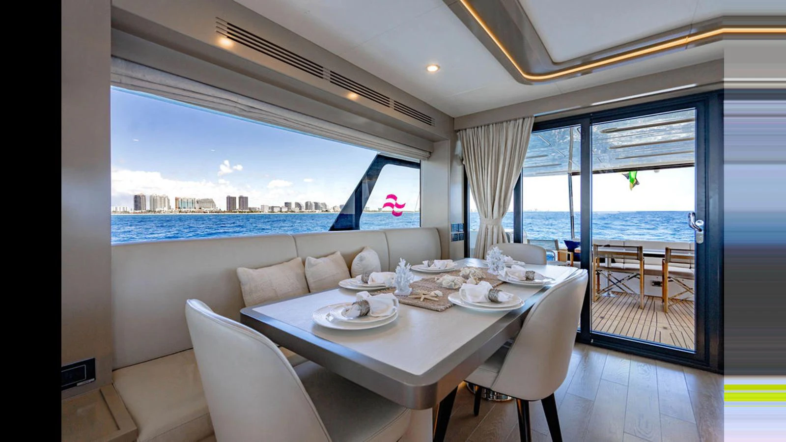 The yacht's dining area offers a luxurious setting with a stunning ocean view through large windows. aboard NIVASA Yacht for Sale