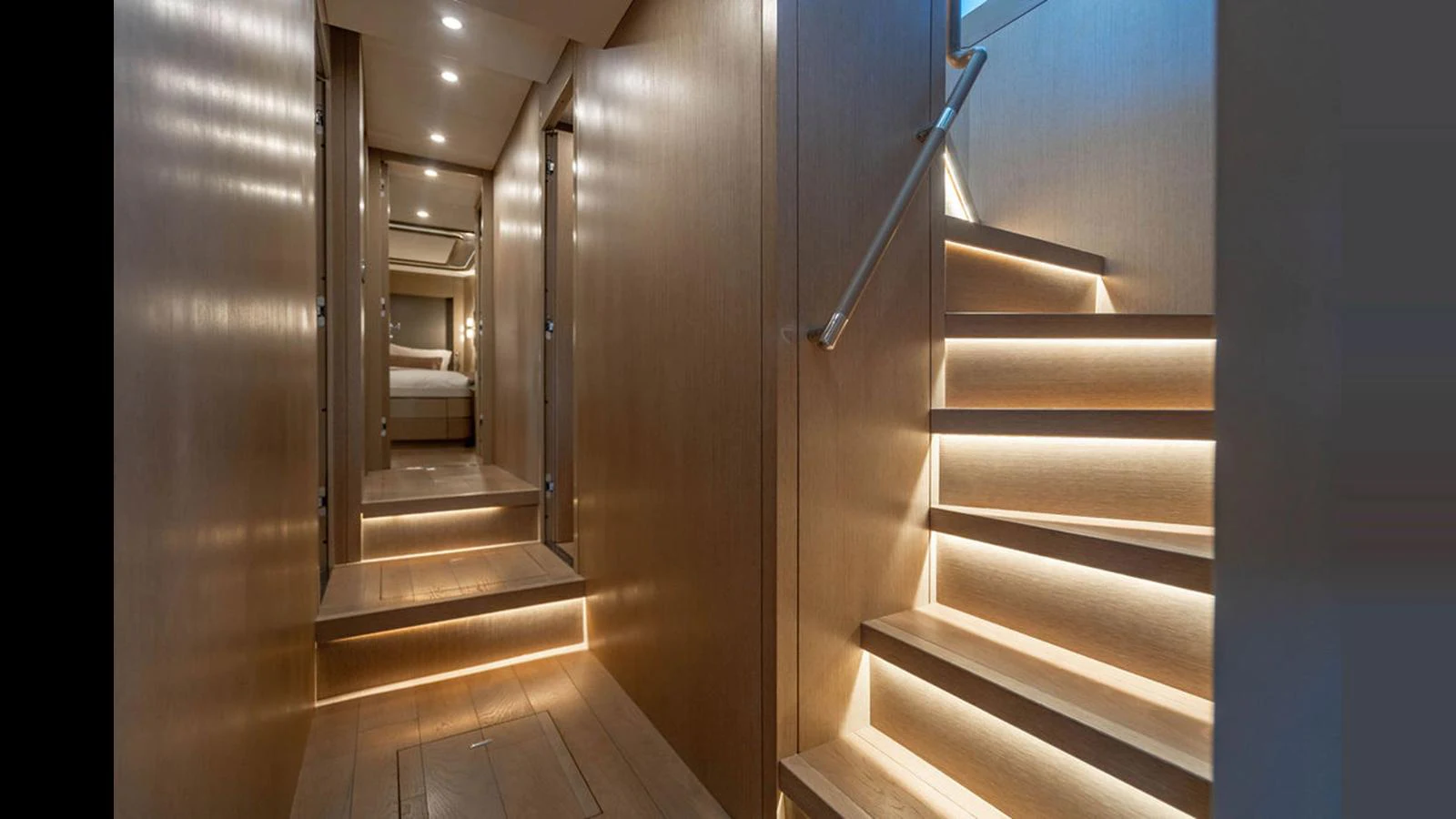 A modern yacht interior featuring a well-lit staircase and a hallway leading to a bedroom. aboard NIVASA Yacht for Sale
