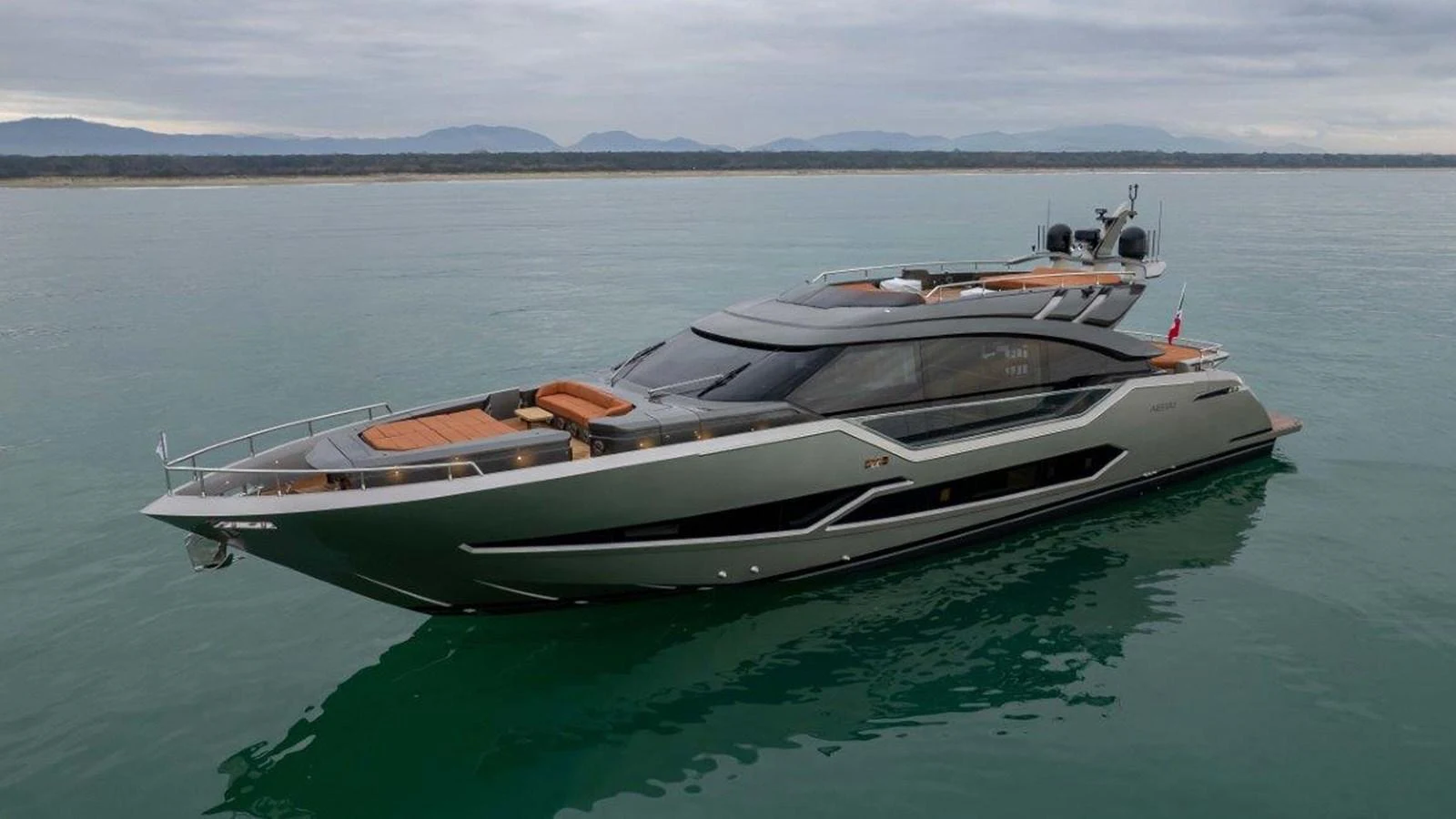 A sleek and modern yacht glides gracefully on calm waters under a cloudy sky. aboard AB 100/05 Yacht for Sale