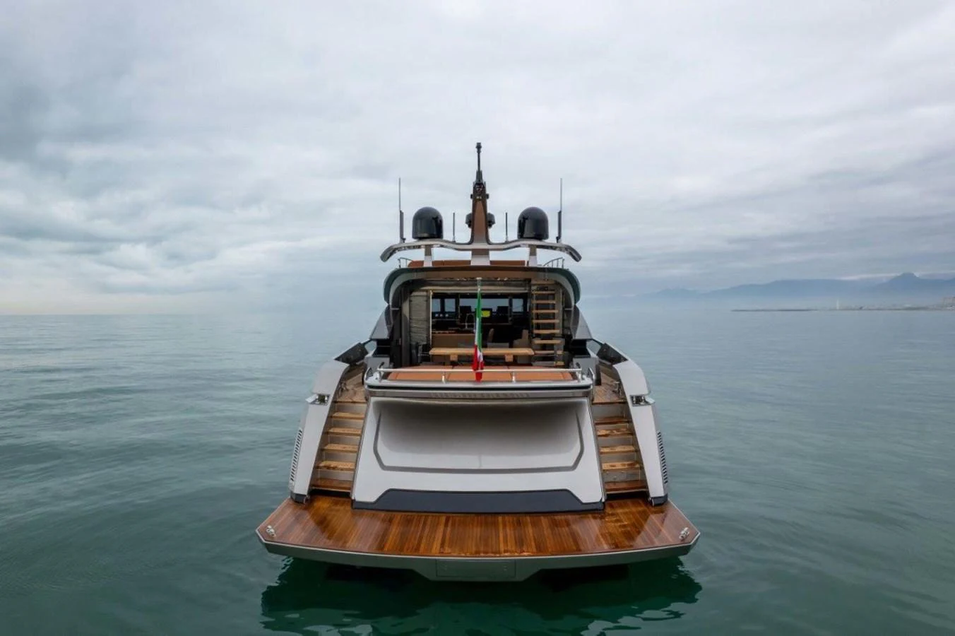 A sleek yacht with a modern design is seen from the stern, showcasing its spacious aft deck and elegant lines. aboard AB 100/05 Yacht for Sale