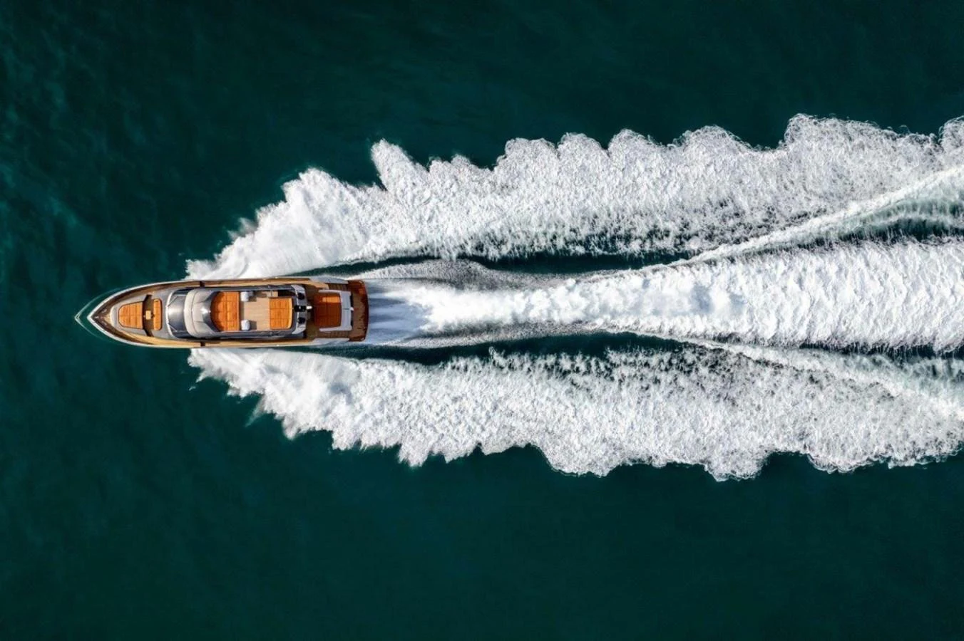 An aerial view of a sleek yacht cruising through the water, leaving a dynamic wake behind. aboard AB 100/05 Yacht for Sale
