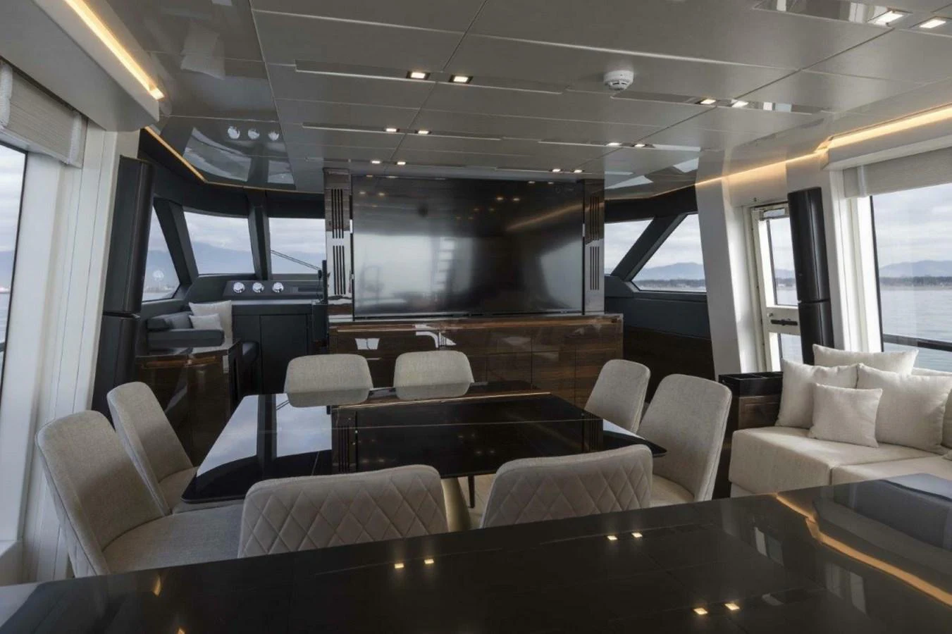 The yacht's interior features a modern and spacious dining and lounging area with large windows offering panoramic views. aboard AB 100/05 Yacht for Sale