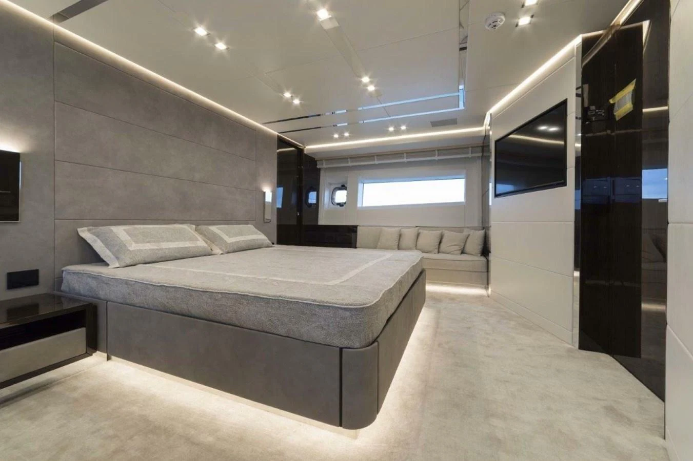 The master stateroom features a spacious bed, modern lighting, and a comfortable seating area. aboard AB 100/05 Yacht for Sale