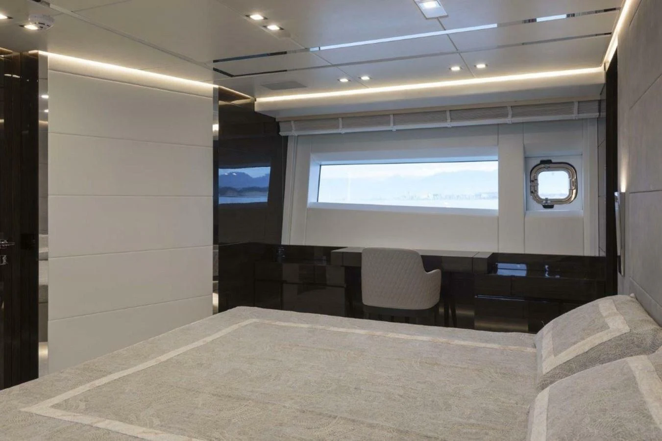 The master stateroom features a large bed, modern furnishings, and a panoramic window with a serene view. aboard AB 100/05 Yacht for Sale