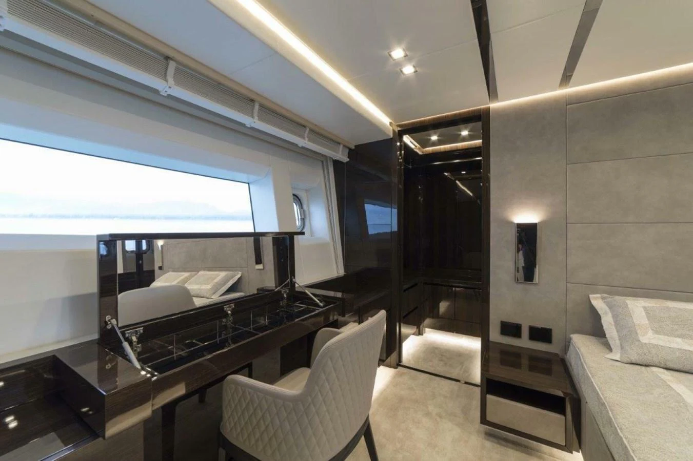 The stateroom features a sleek desk area with modern furnishings and a large window offering natural light. aboard AB 100/05 Yacht for Sale