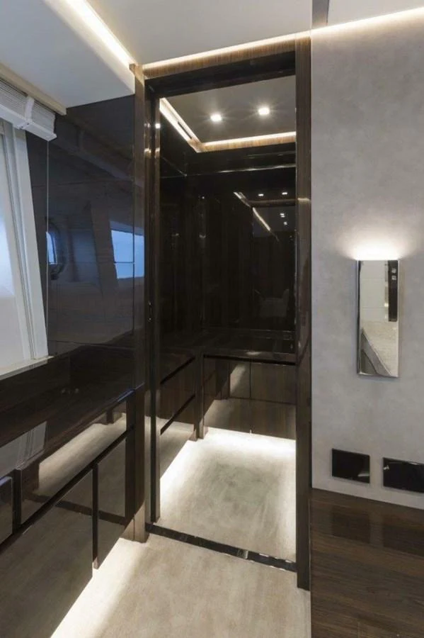 The yacht's interior features a sleek, modern hallway with reflective surfaces and ambient lighting. aboard AB 100/05 Yacht for Sale