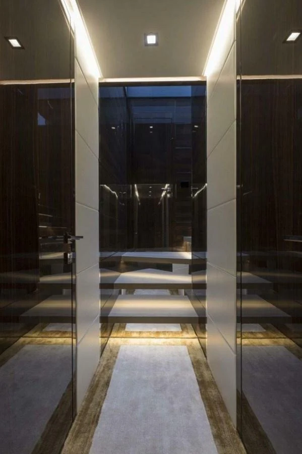 A sleek and modern hallway with reflective surfaces and ambient lighting. aboard AB 100/05 Yacht for Sale