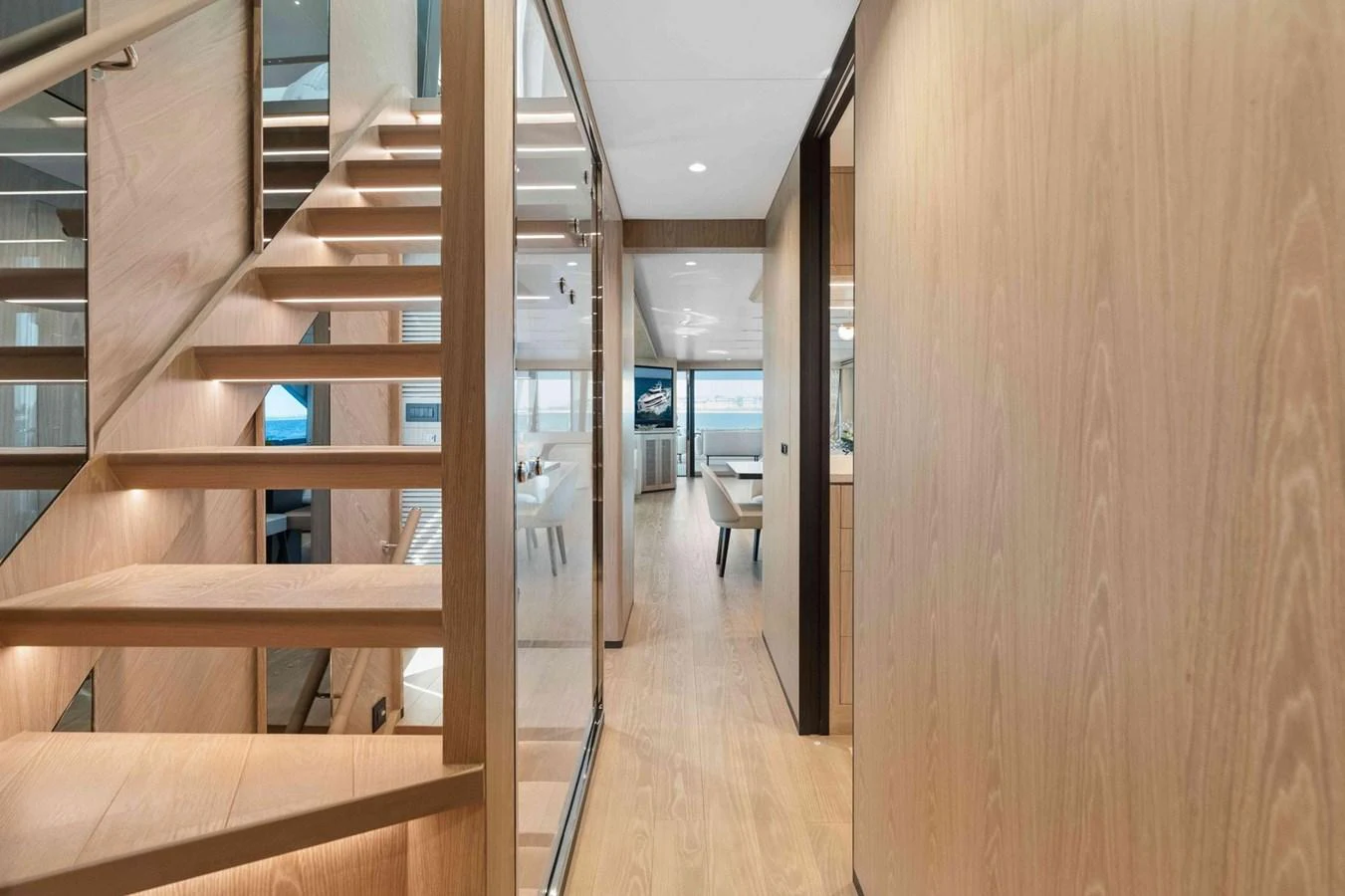 A modern yacht interior hallway featuring wooden stairs and sleek design elements. aboard THE ROCK Yacht for Sale