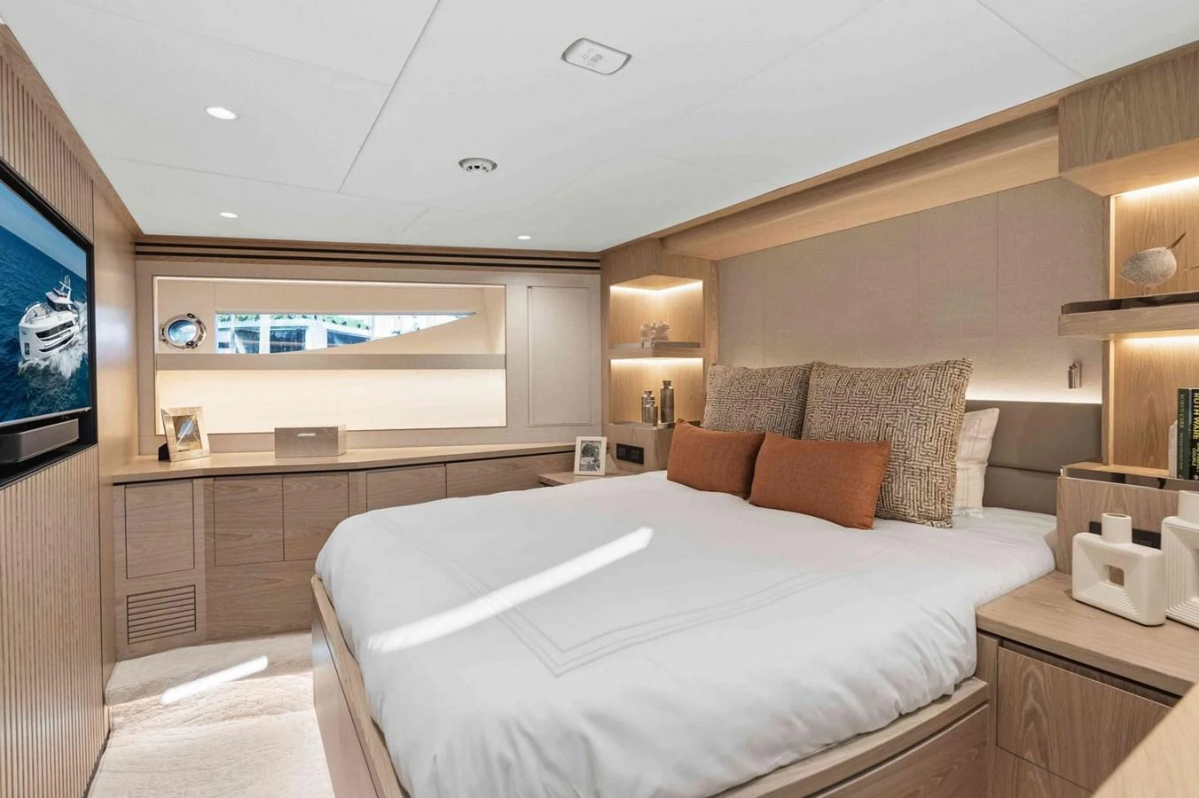 The stateroom features a luxurious bed with plush pillows and elegant wooden cabinetry, creating a serene and inviting atmosphere. aboard THE ROCK Yacht for Sale
