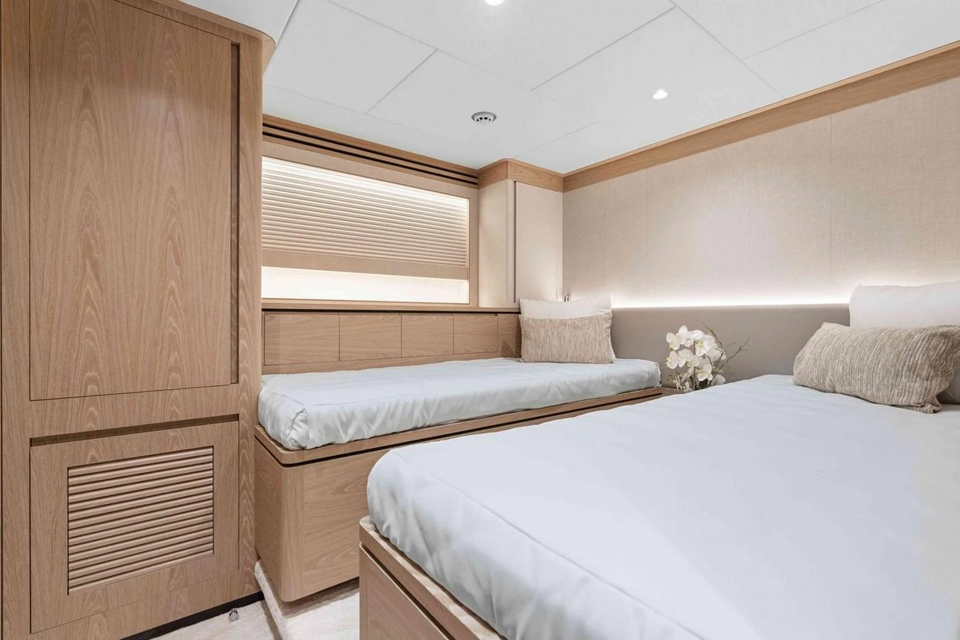 The guest stateroom features twin beds with elegant wood finishes and soft lighting. aboard THE ROCK Yacht for Sale