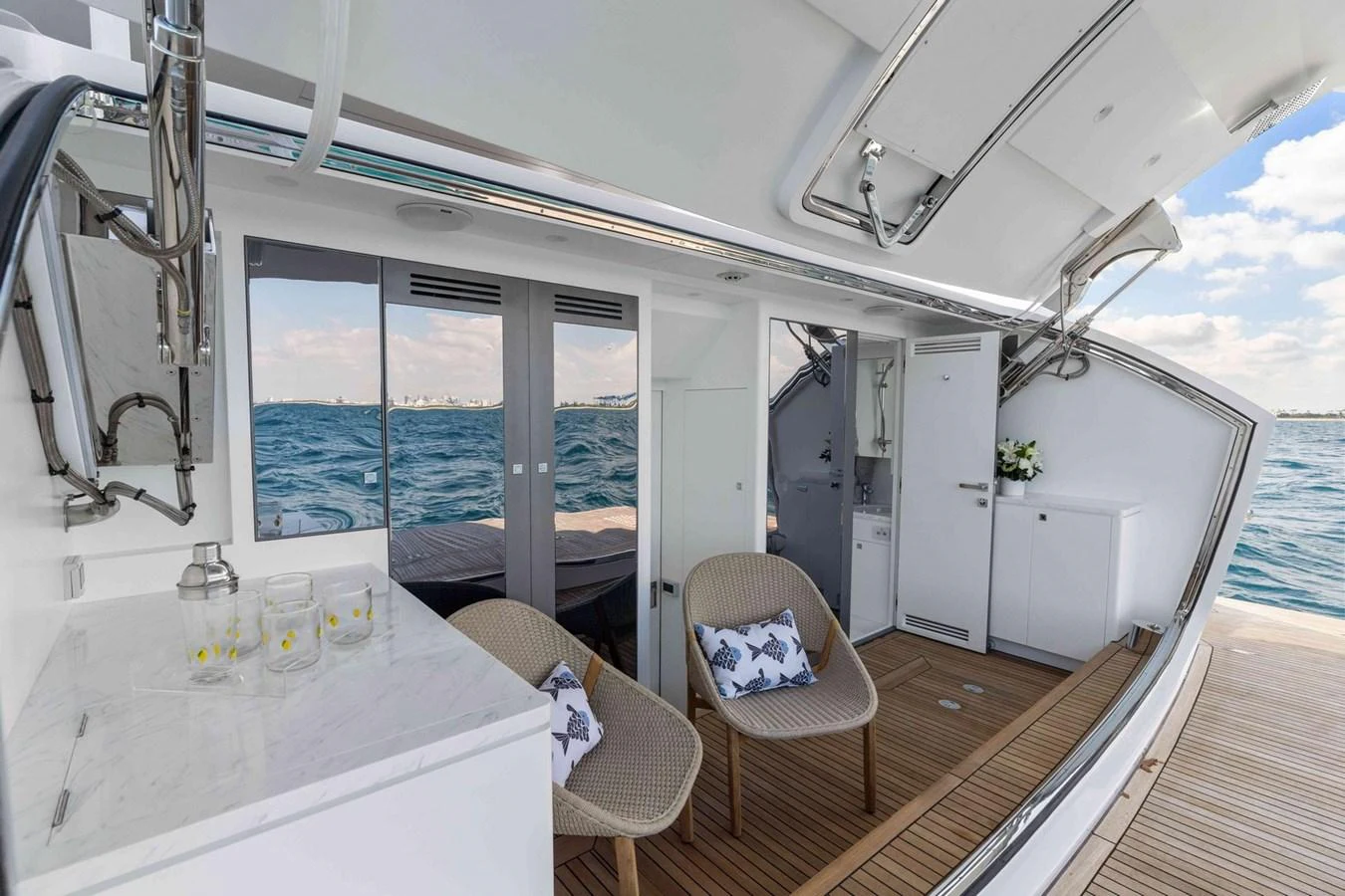 The aft deck features comfortable seating and a small kitchenette, perfect for enjoying the ocean views. aboard THE ROCK Yacht for Sale