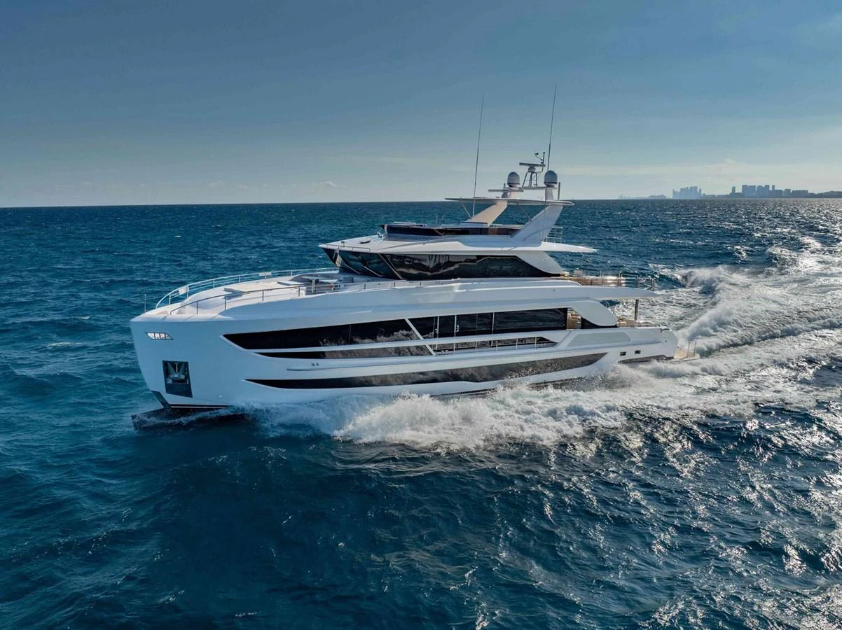 A sleek and modern yacht cruises swiftly through the open sea under clear skies. aboard THE ROCK Yacht for Sale