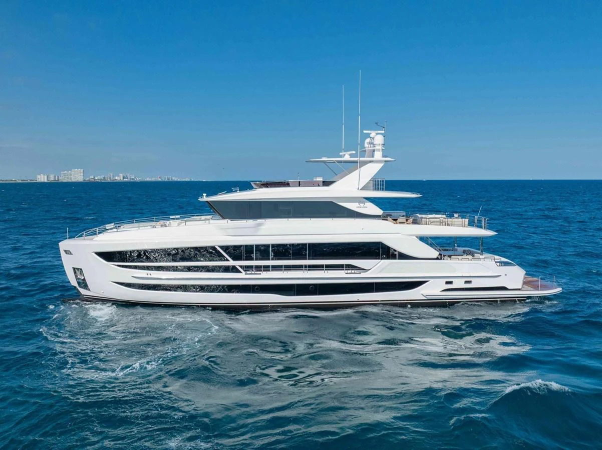 A sleek and modern yacht cruising on the open sea under a clear blue sky. aboard THE ROCK Yacht for Sale
