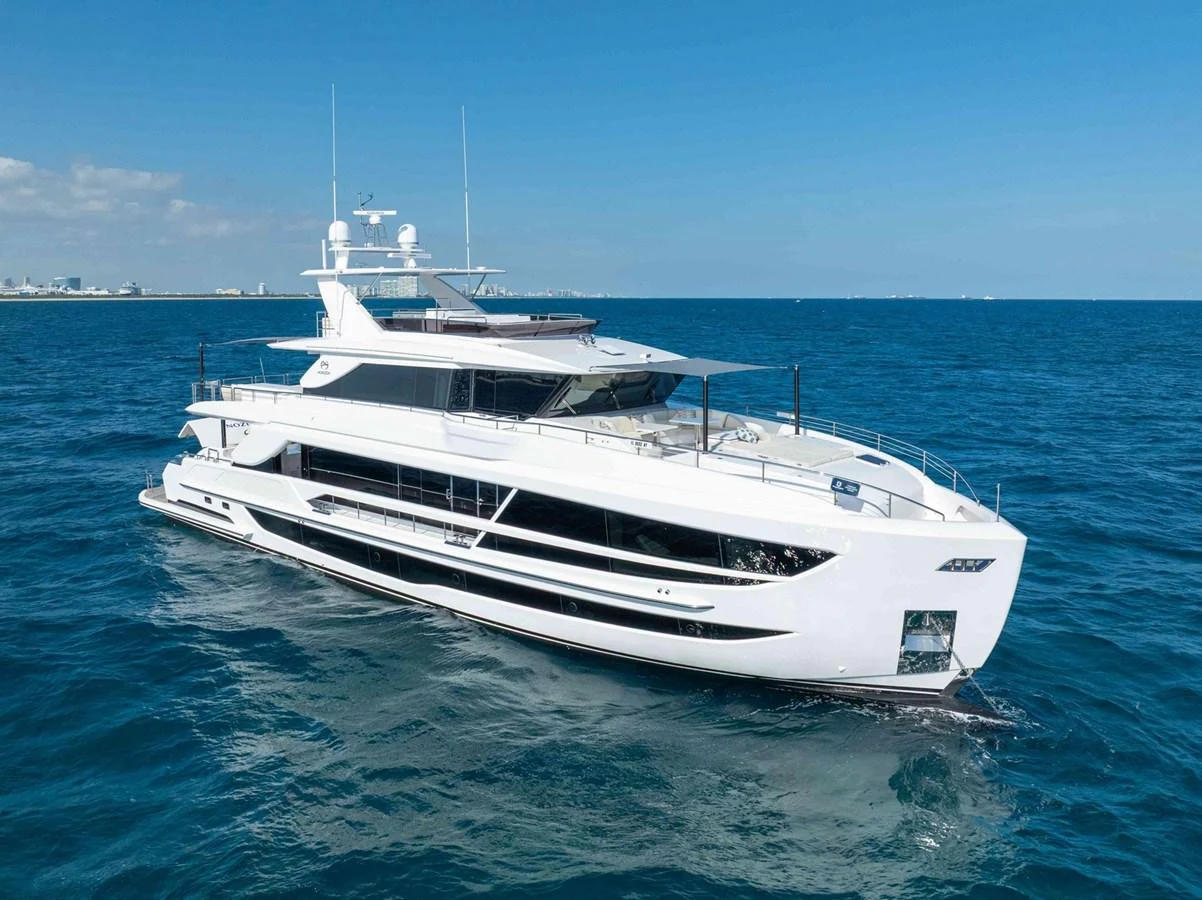 A sleek and modern yacht glides gracefully on the open sea under a clear blue sky. aboard THE ROCK Yacht for Sale
