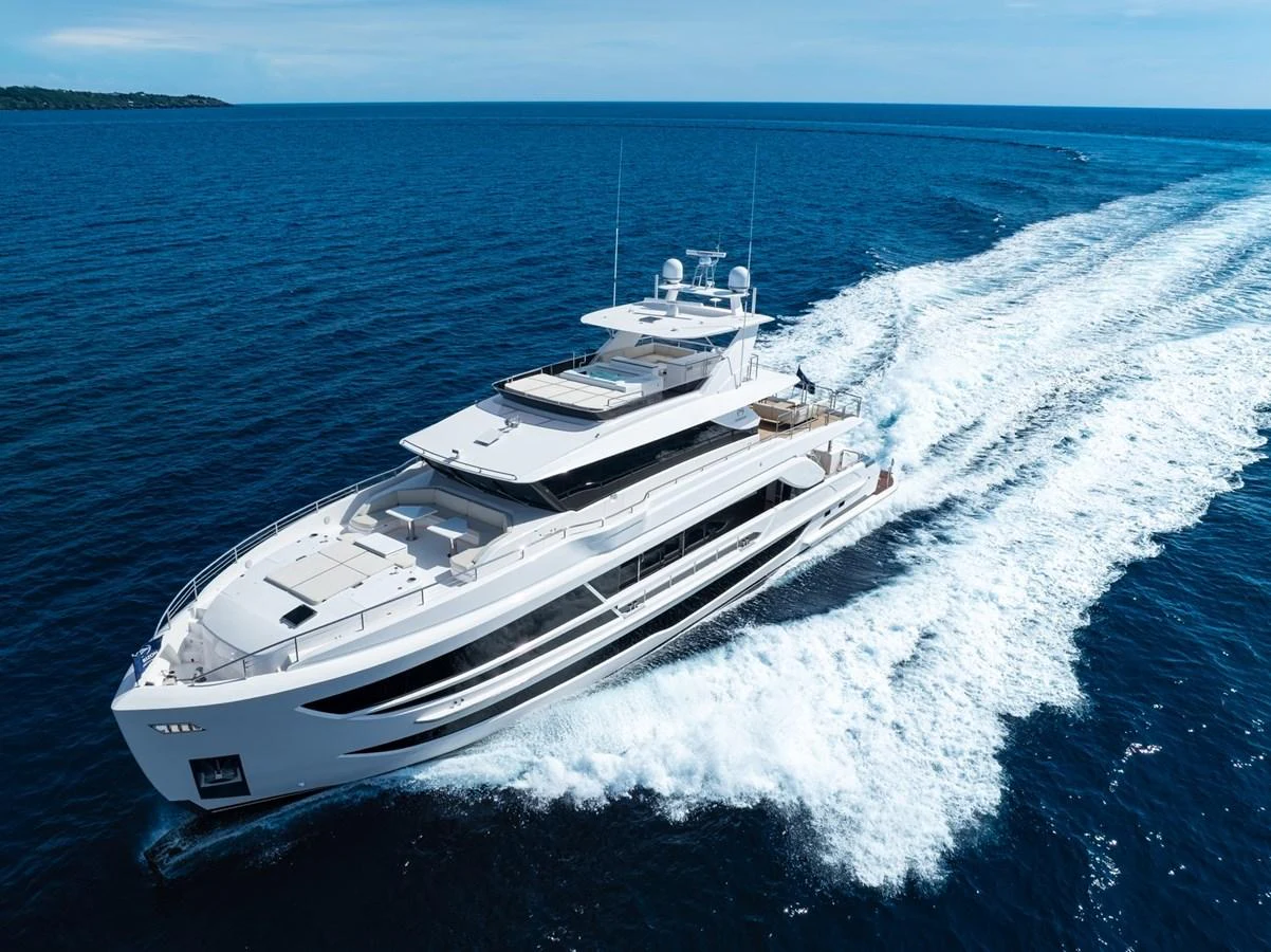 A sleek and modern yacht cruises swiftly through the open sea, leaving a trail of white wake behind. aboard THE ROCK Yacht for Sale