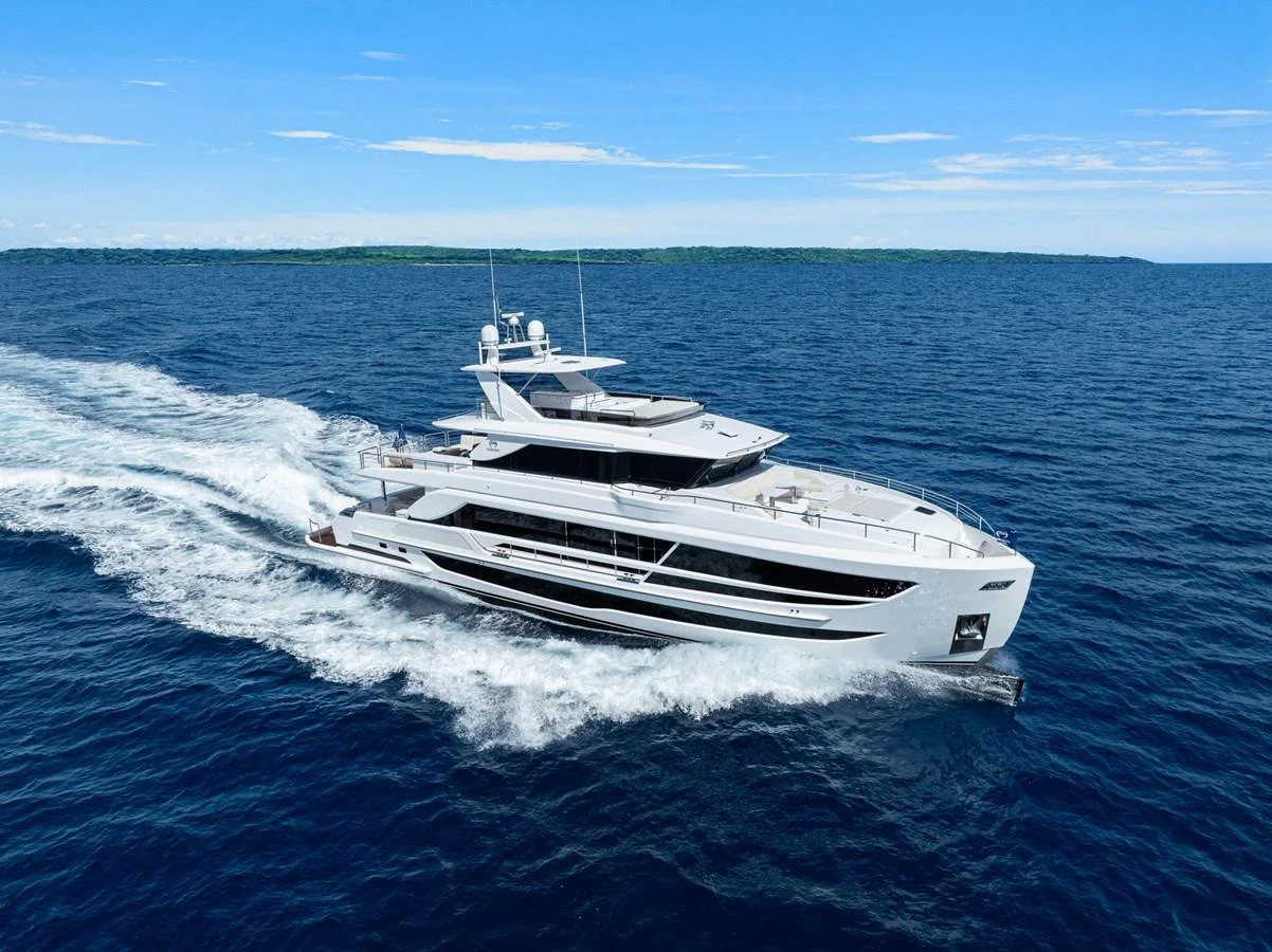A sleek and modern yacht cruising on open waters under a clear blue sky. aboard THE ROCK Yacht for Sale