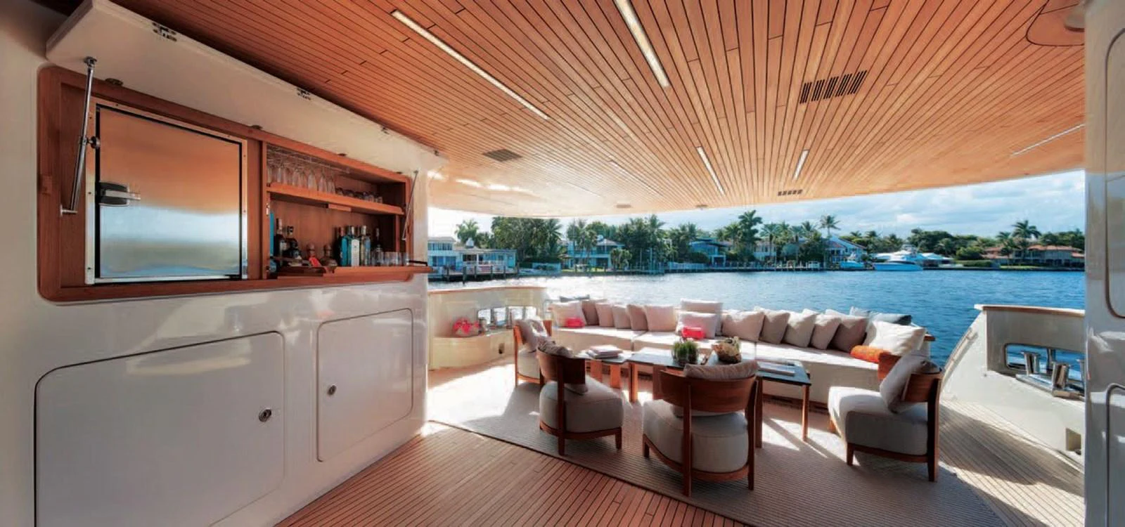 The aft deck features a spacious seating area with a bar, offering stunning views of the water. aboard O Yacht for Sale