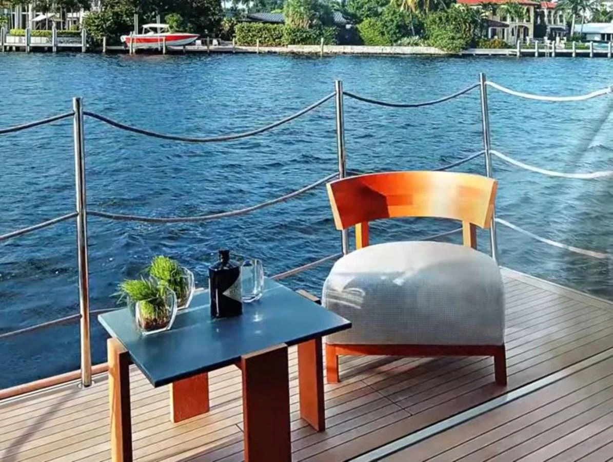 A serene deck area with a comfortable chair and a small table overlooking the water. aboard O Yacht for Sale