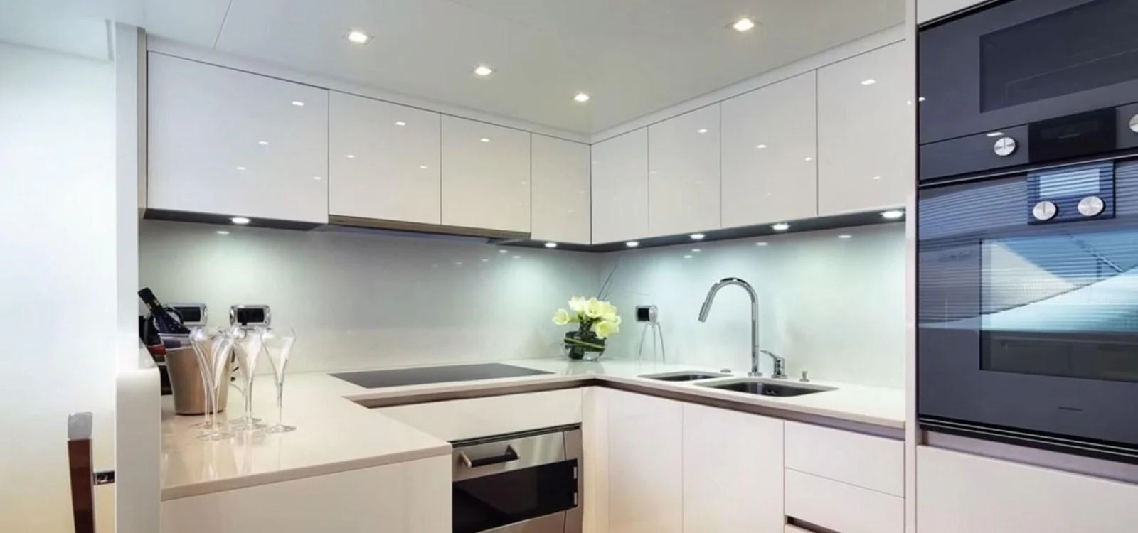 The yacht's galley features modern appliances and sleek white cabinetry, creating a bright and functional space. aboard O Yacht for Sale