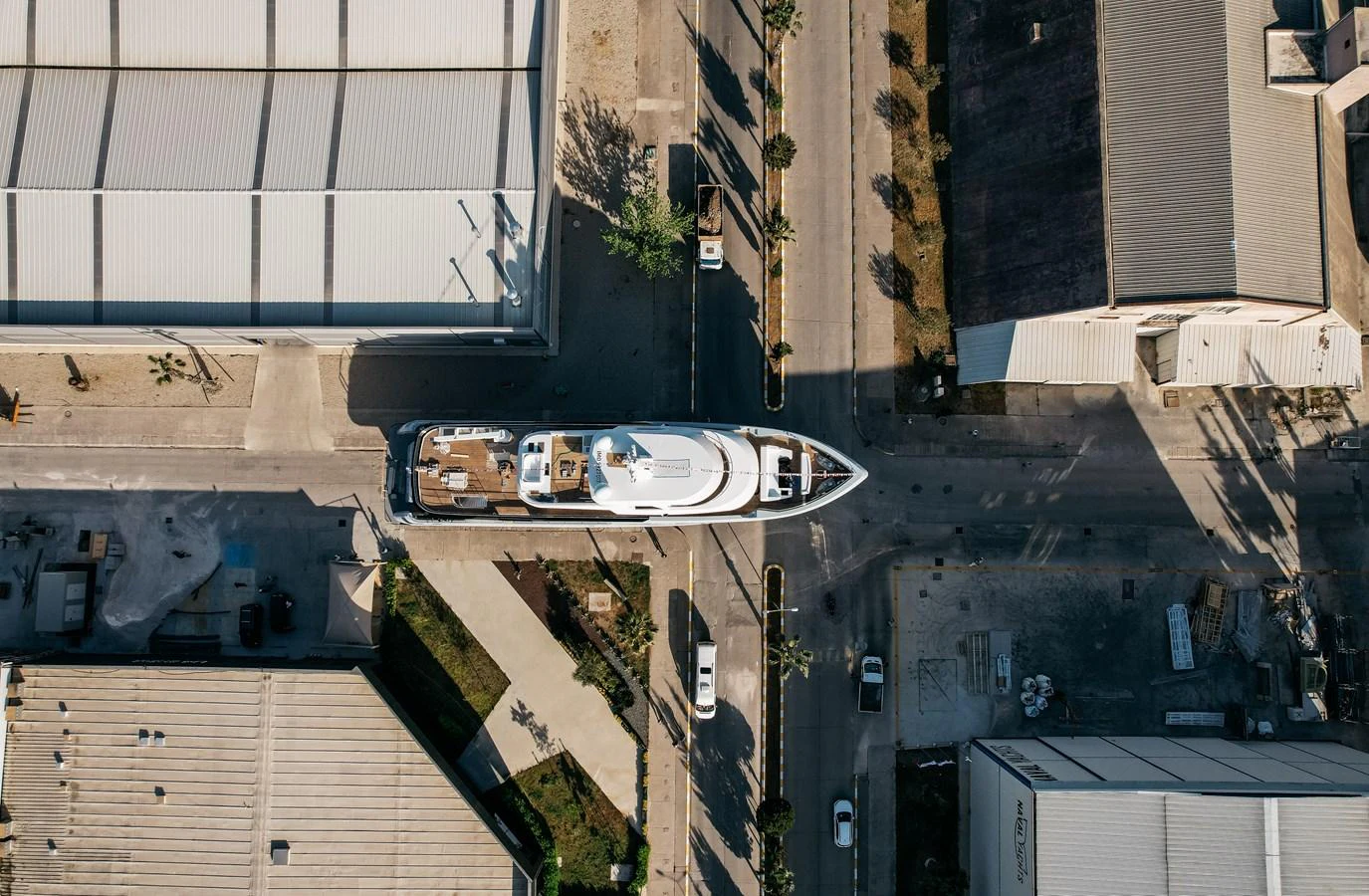 An aerial view of a yacht docked in an industrial area, showcasing its sleek design and spacious deck. aboard BERING 145 Yacht for Sale