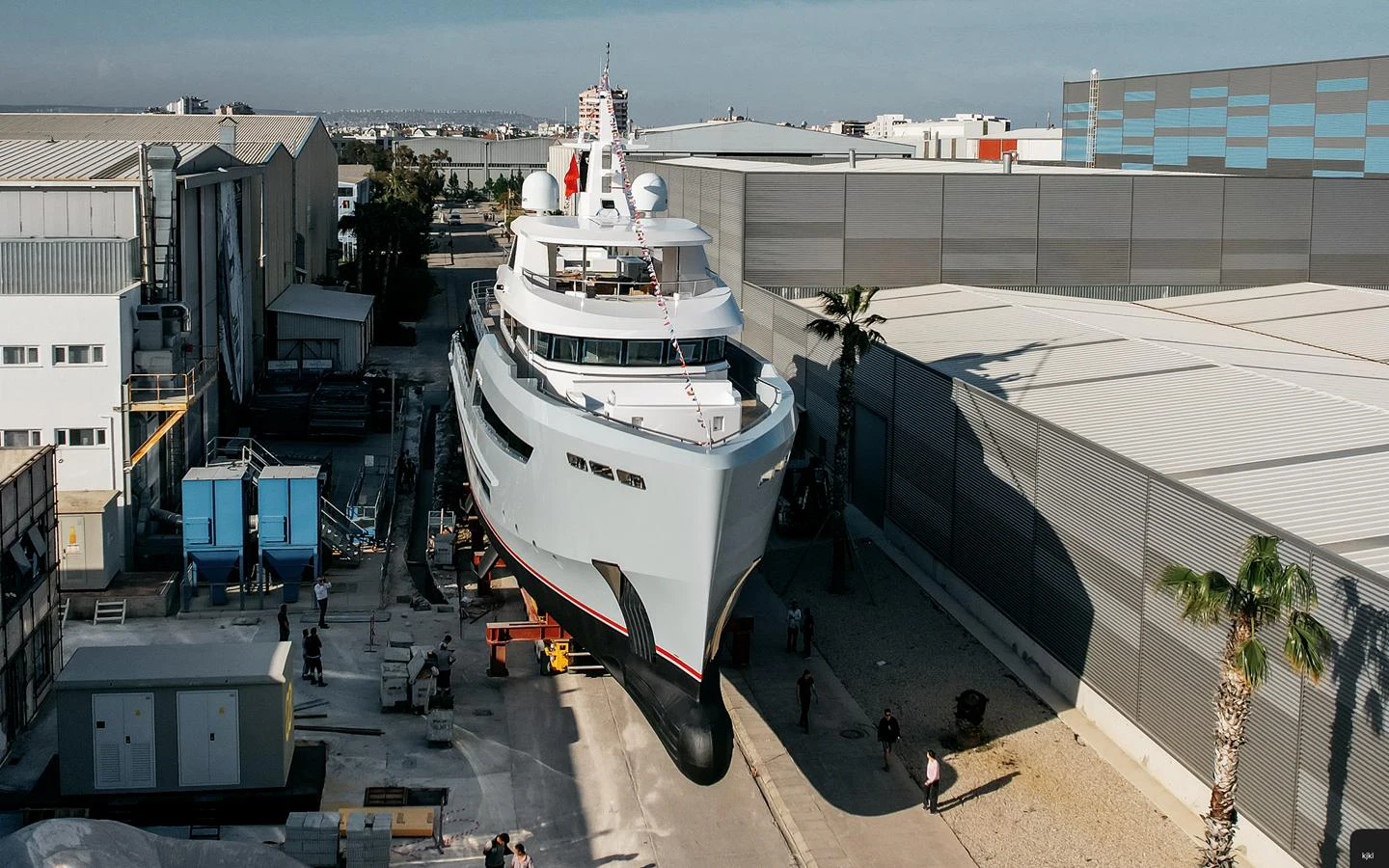 The yacht is seen in a shipyard, showcasing its sleek design and modern construction. aboard BERING 145 Yacht for Sale