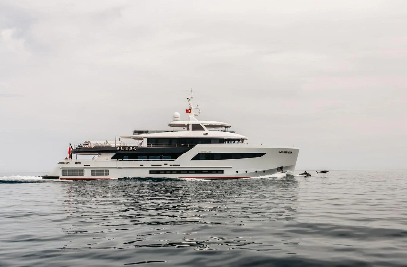 A sleek and modern yacht cruises smoothly on calm waters under a cloudy sky. aboard BERING 145 Yacht for Sale