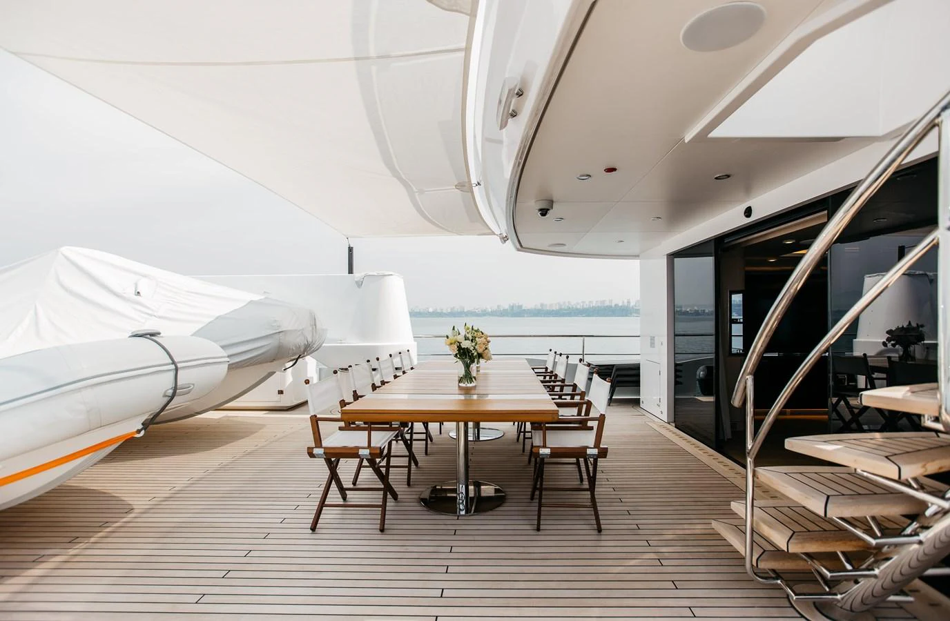 The aft deck features a spacious dining area with a large table and comfortable seating, perfect for alfresco meals. aboard BERING 145 Yacht for Sale