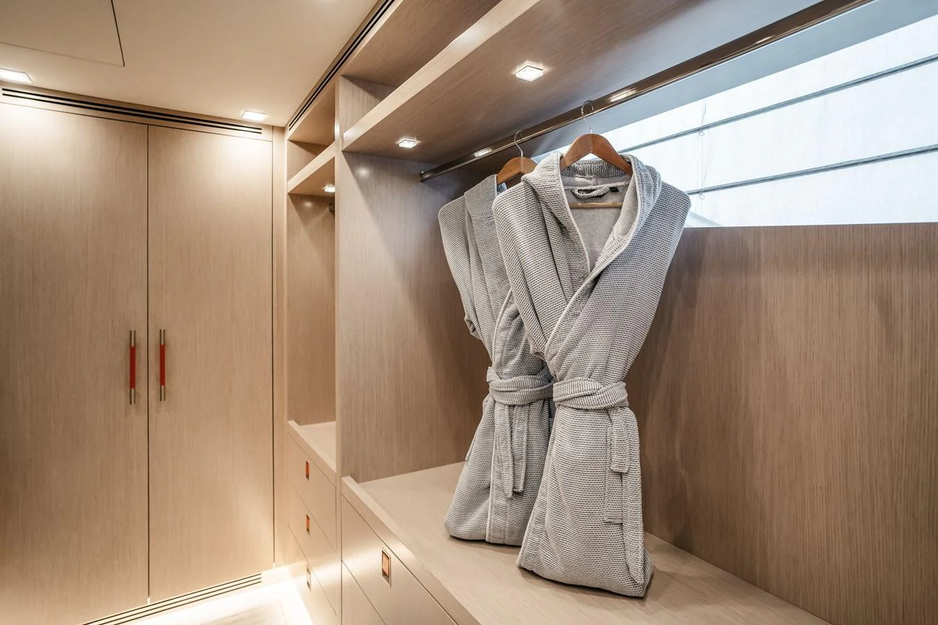 The yacht's interior features a well-appointed dressing area with luxurious bathrobes and ample storage. aboard BERING 145 Yacht for Sale