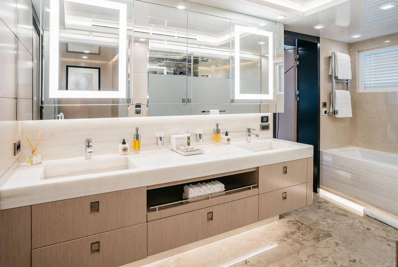 The yacht's bathroom features a luxurious double vanity with ample storage and modern lighting. aboard BERING 145 Yacht for Sale