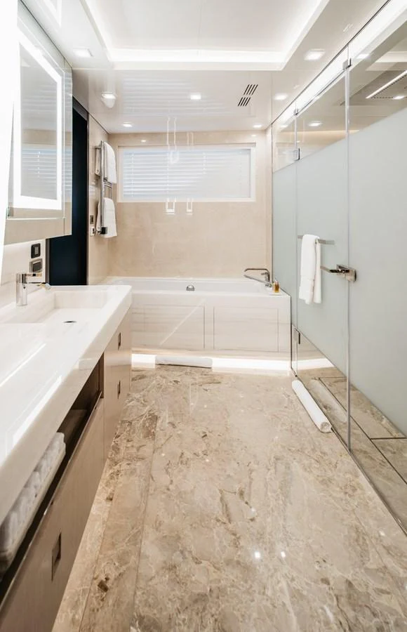 The yacht's bathroom features luxurious marble flooring and modern fixtures. aboard BERING 145 Yacht for Sale