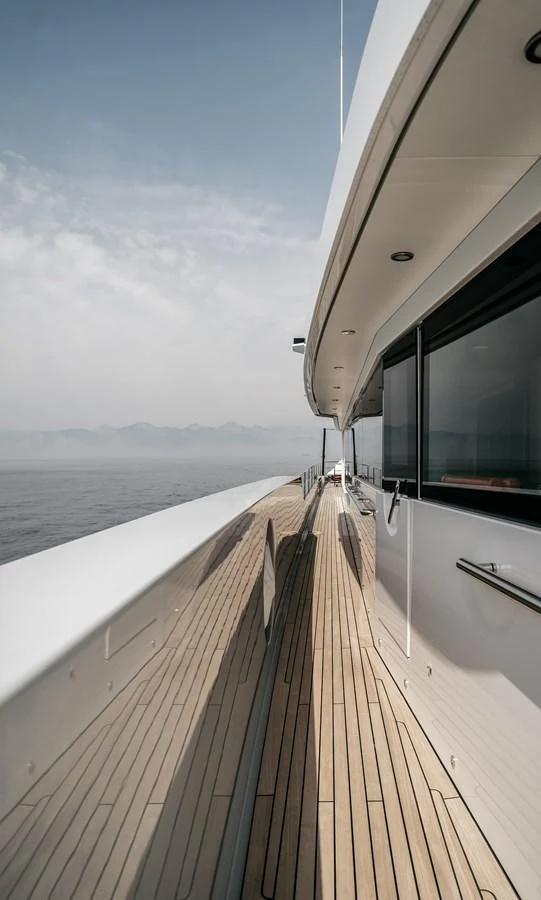 The sleek side deck of the yacht offers a serene view of the open water. aboard BERING 145 Yacht for Sale